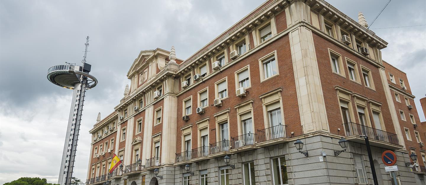 Fachada de la AECID, con el Faro de Moncloa al fondo
